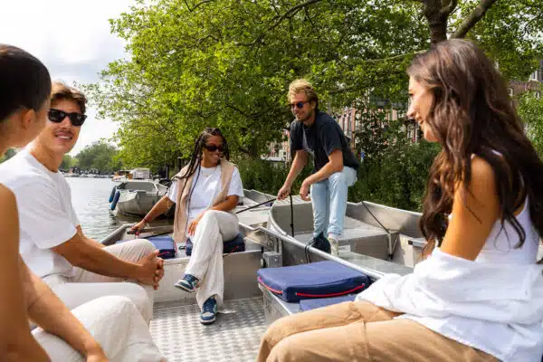 Boaty-Bootverhuur-Centrum-van-Amsterdam-1-600x400.jpg Een man legt de vaarroutes in Amsterdam uit aan een man en vrouw.