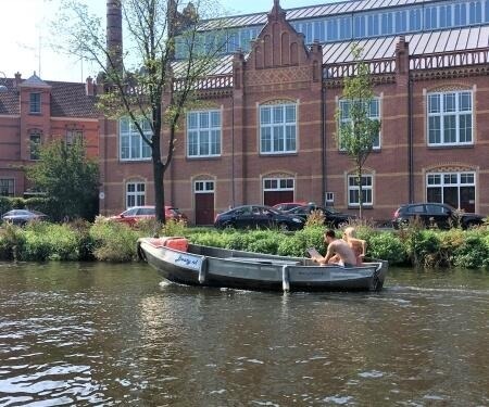 Twee mensen in een sloep op een Amsterdamse gracht